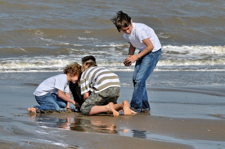 three people are standing on the beach and playing