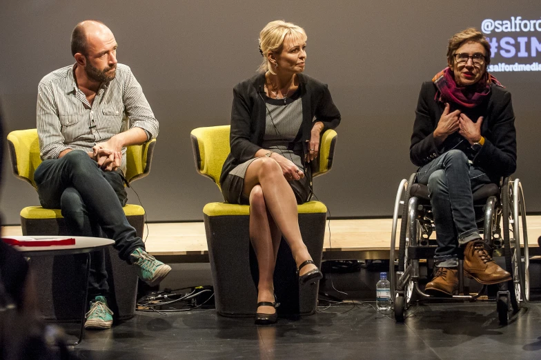 some people sitting in chairs together in front of a microphone