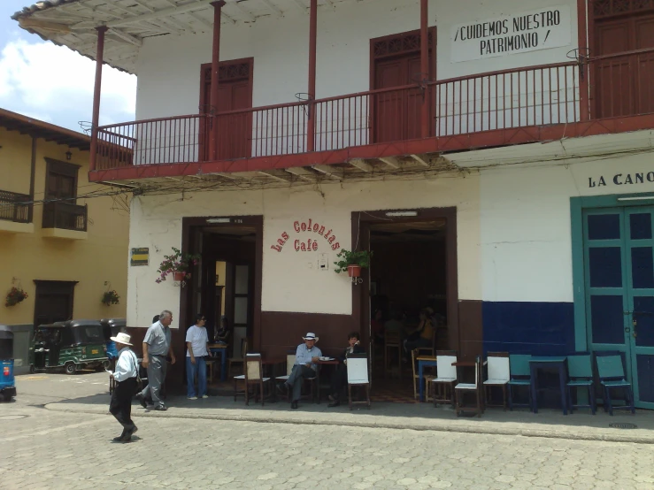 a group of people sit outside of a building