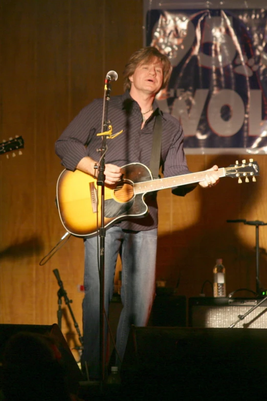 the man is playing his guitar at a concert