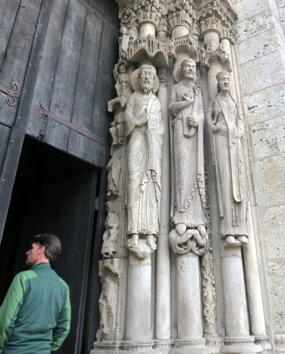 a man standing next to a statue near an entrance