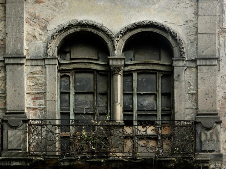 a balcony has a black iron railing and many windows