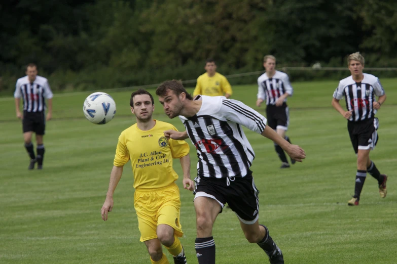 a soccer player wearing yellow kicks the ball