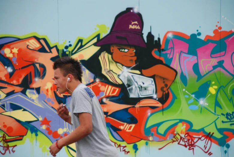 a young man in front of colorful wall with graffiti