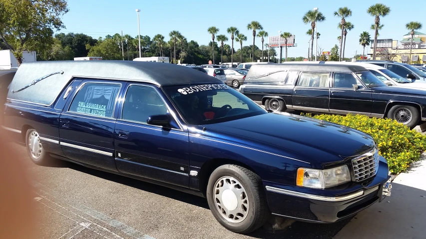 a blue lincoln limousine sits in front of a parking lot