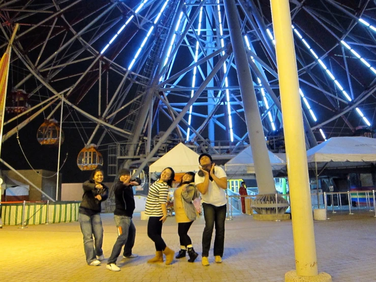 four people pose for a picture under the ceiling of a ferris wheel
