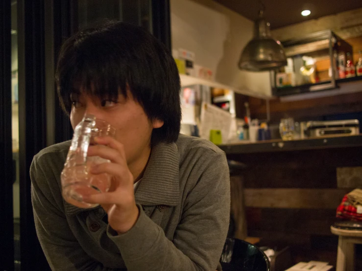 a woman with short dark hair holds a glass of water