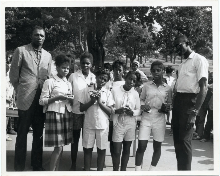 a group of people stand on the side walk