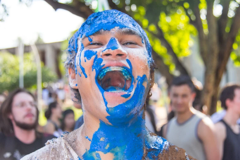 a guy with a face paint painted blue, yelling