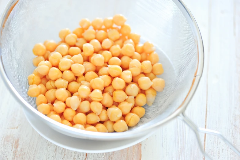 a white bowl filled with yellow and brown small kernels