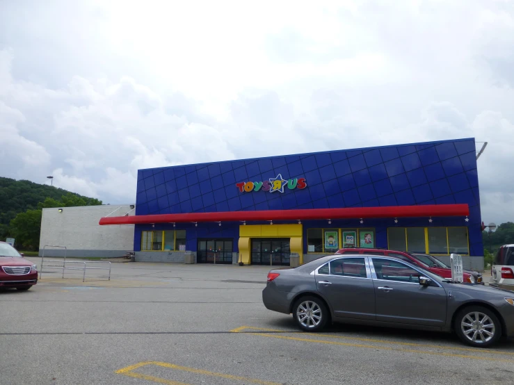 a car sits parked outside the store near other cars