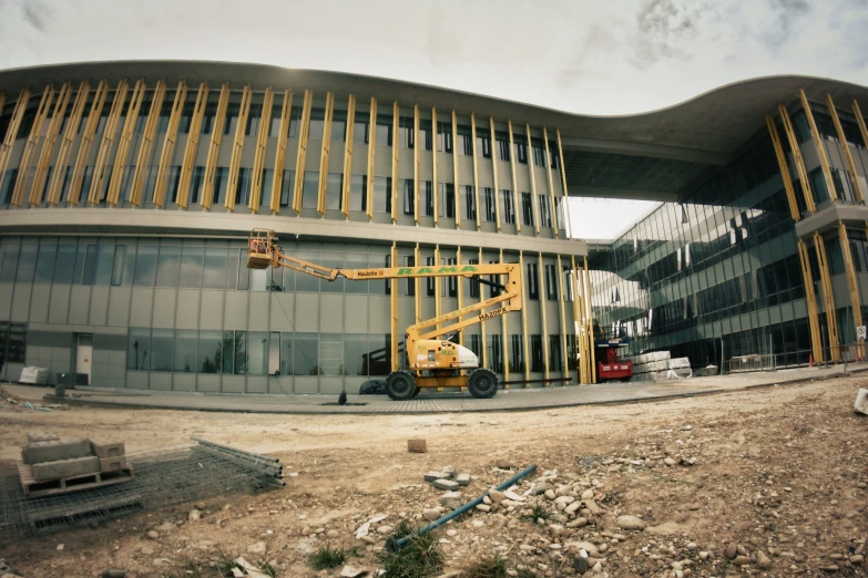 a yellow truck is parked outside of a large building