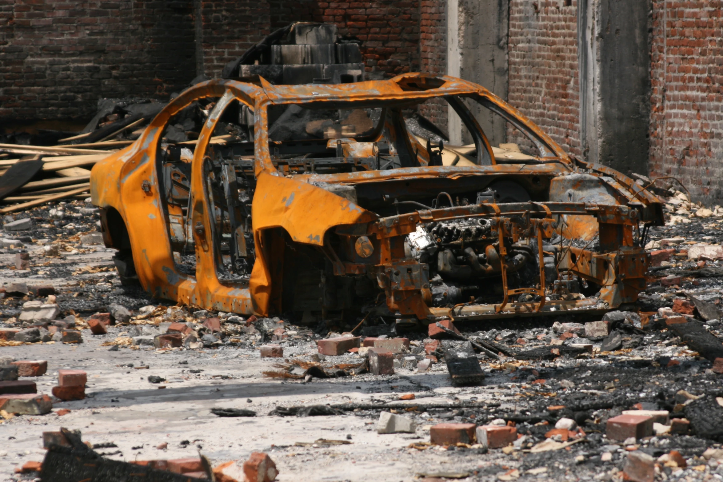 a burnt out car sitting in the middle of rubble