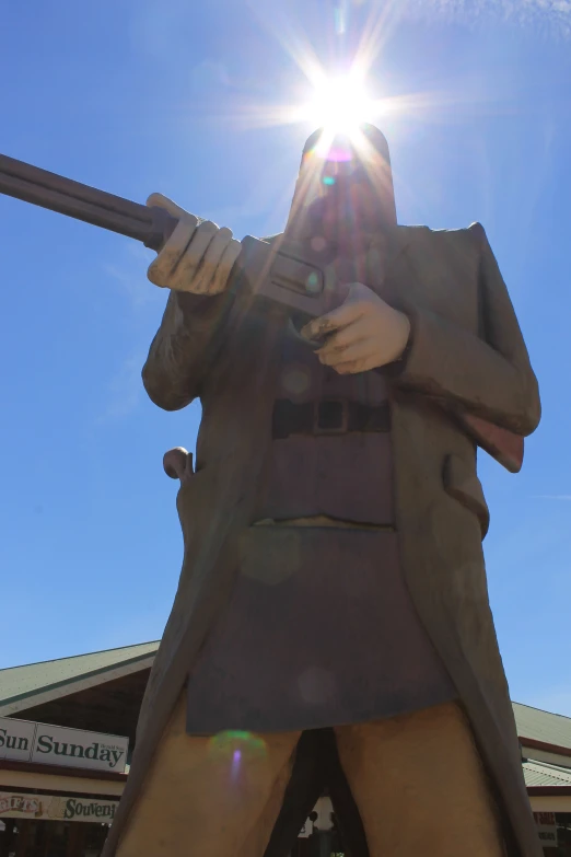 statue holding a gun and looking at a large sky