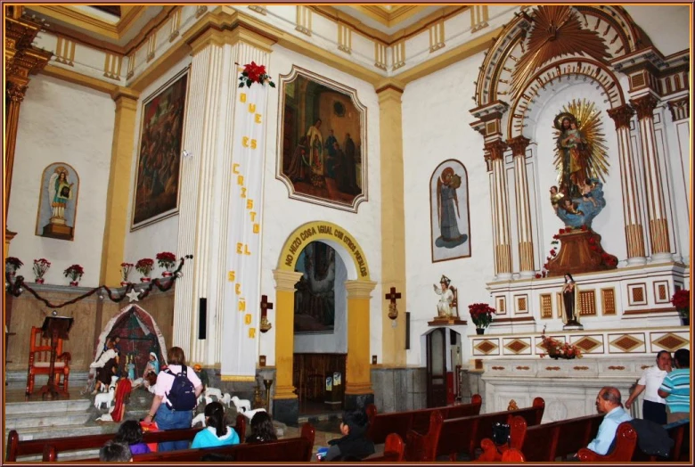 people seated in pews as a procession takes place inside of a church