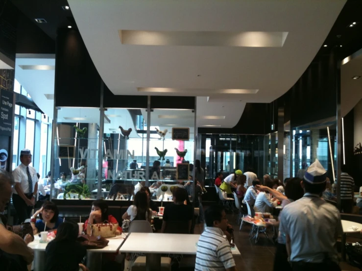 a restaurant is filled with customers and sitting at tables