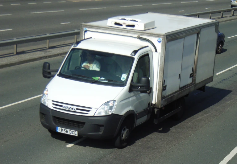 a white van driving on a highway down the street