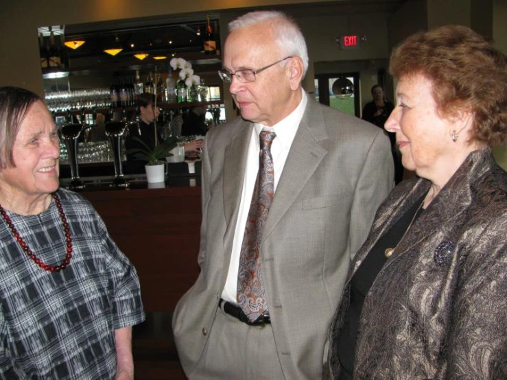 two men and one woman talking to each other