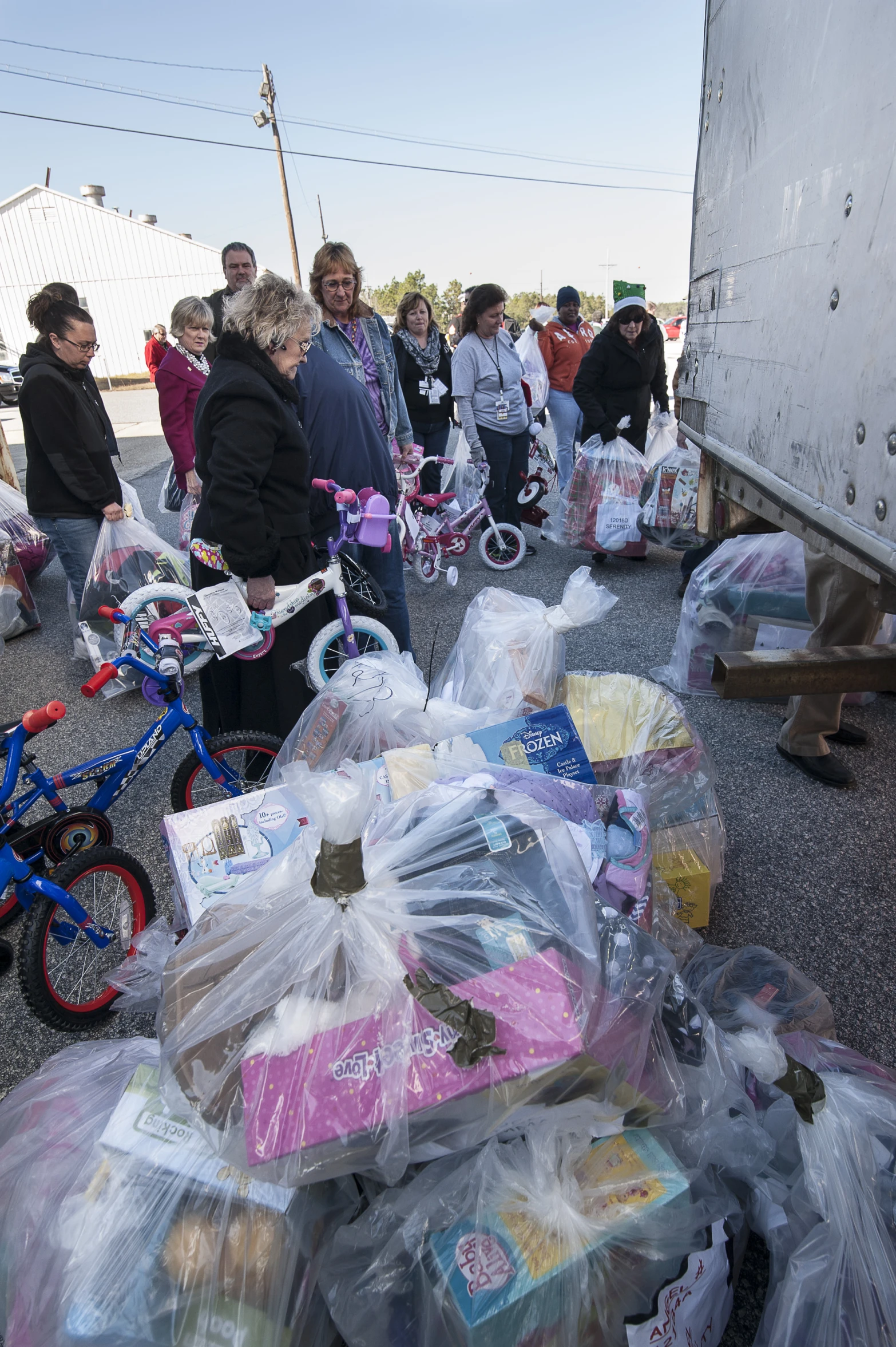 a number of people standing around a pile of items