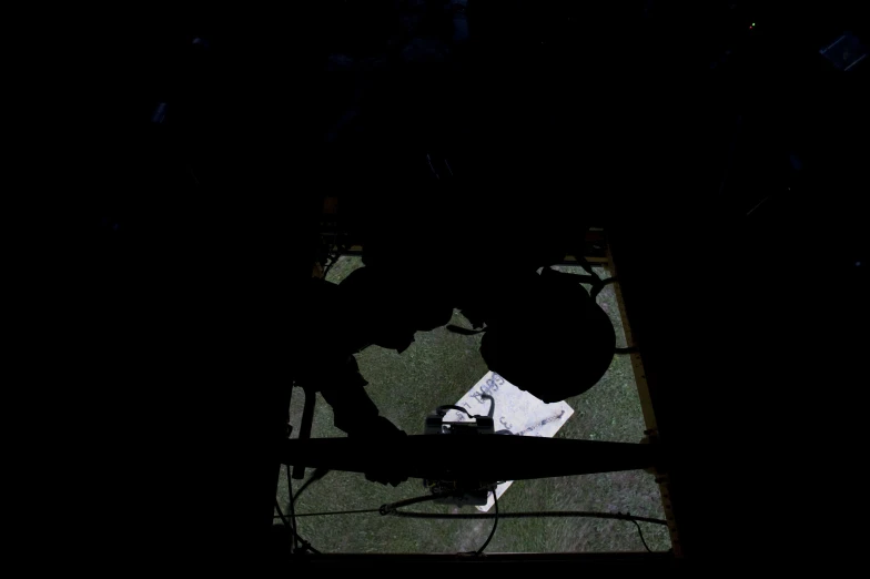 the silhouette of a person using a computer in the dark