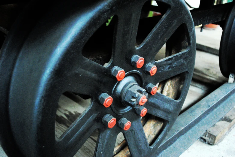 a wagon wheel with a rubber spokes and red bolts