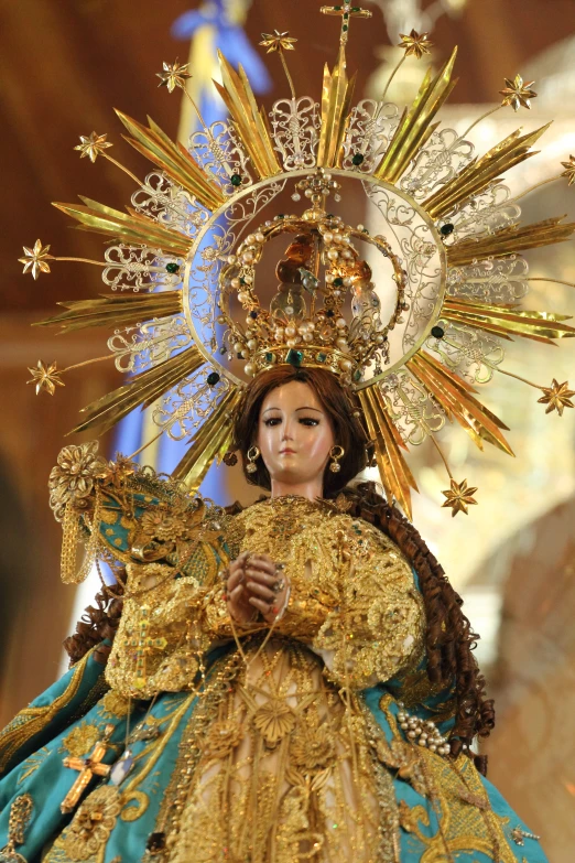 a doll of a virgin wearing gold and blue