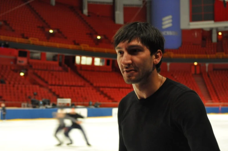 a man standing on an ice rink with a hockey stick