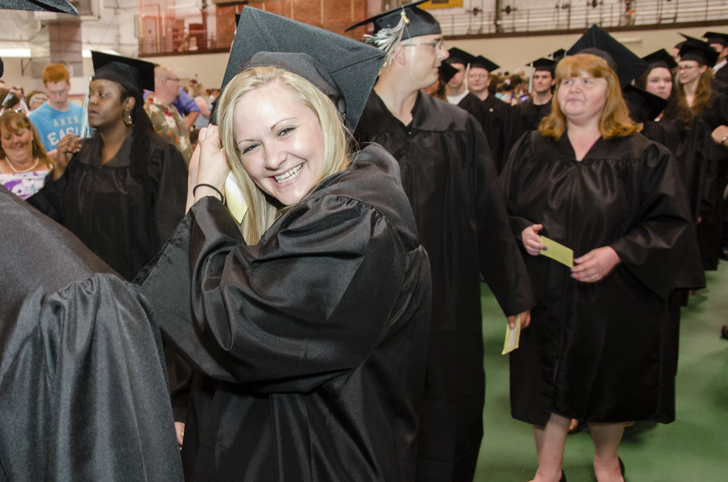 a girl on her graduation day smiles with her friends