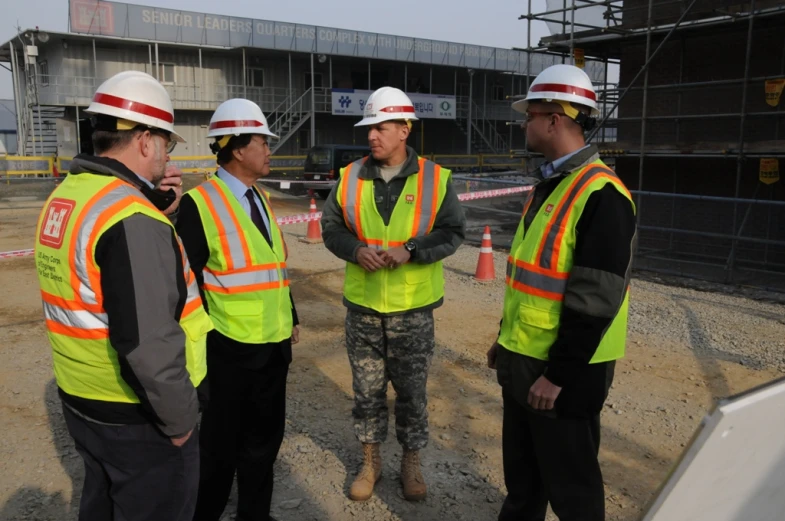 several construction workers talking to each other while wearing hard hats