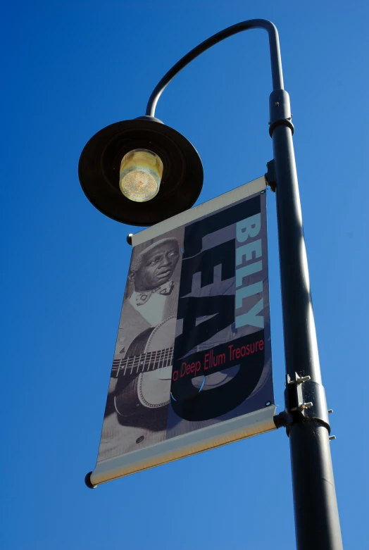 a sign for a concert under the light pole