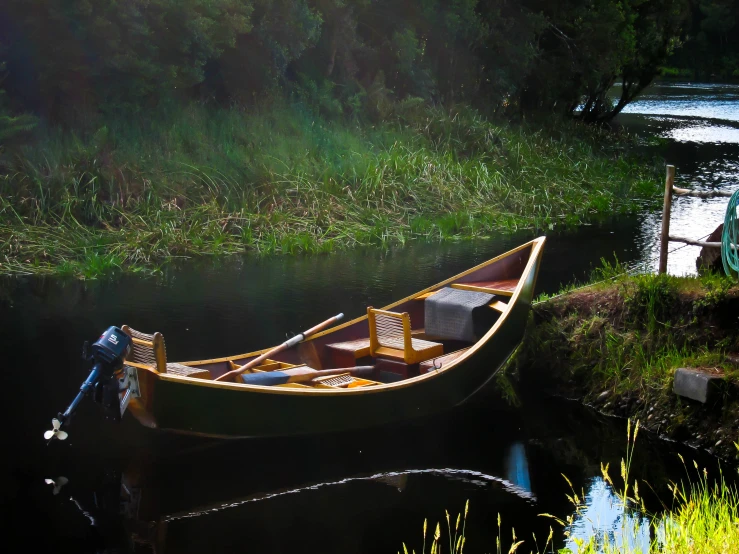 a long row boat is anchored at a small inlet