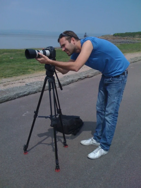 a man in blue shirt taking pictures with camera