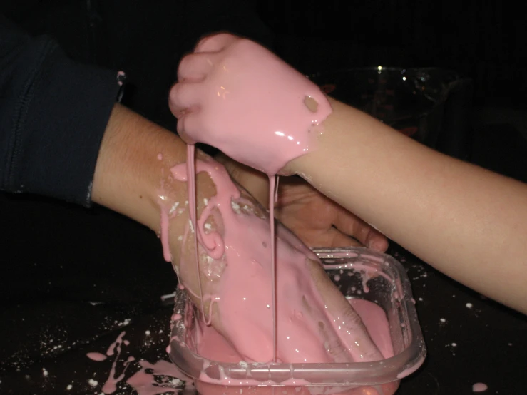 someone getting a dessert at a party with pink icing on it