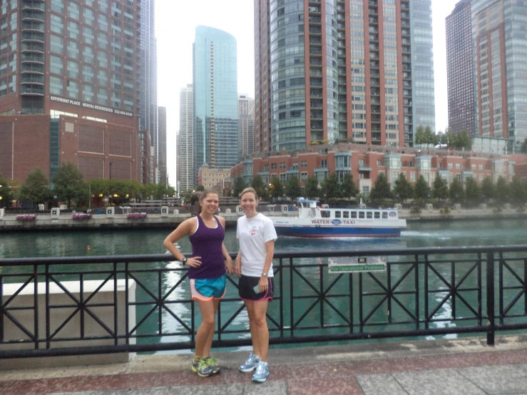 two women are standing by a metal railing