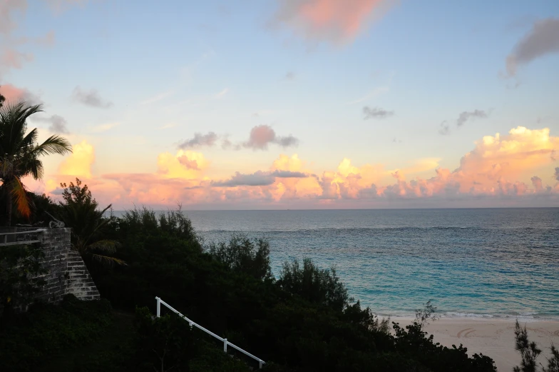 the sun rises over the ocean as seen from a balcony