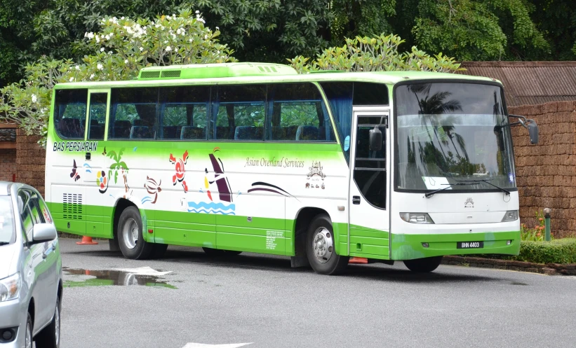 a large green bus parked next to a street