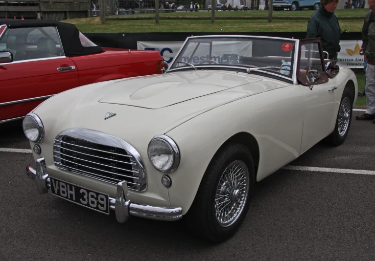 a white car with the top down and other cars in the background