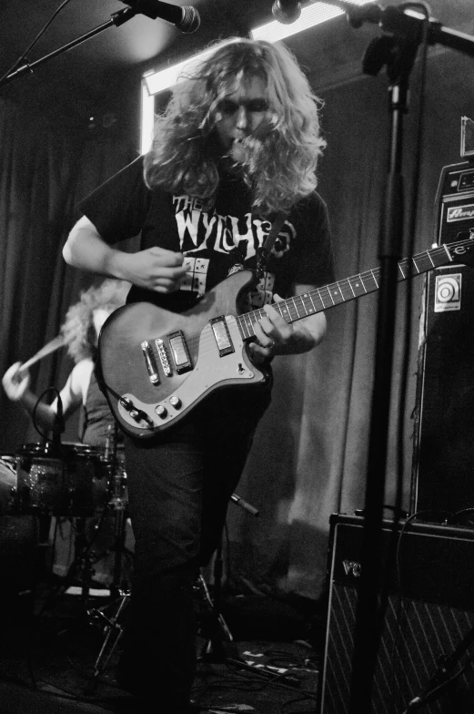 a man playing a guitar in front of some microphones