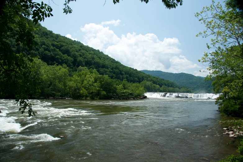 a body of water next to green hillside