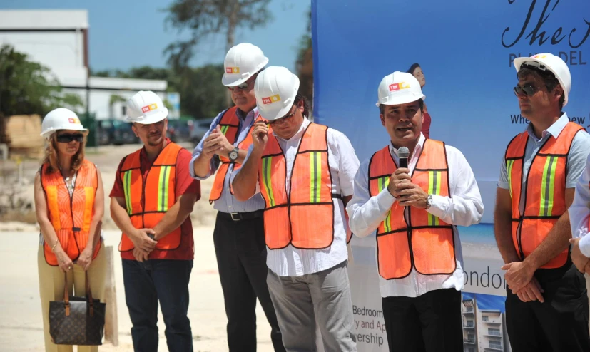 a group of people in construction vests holding microphone