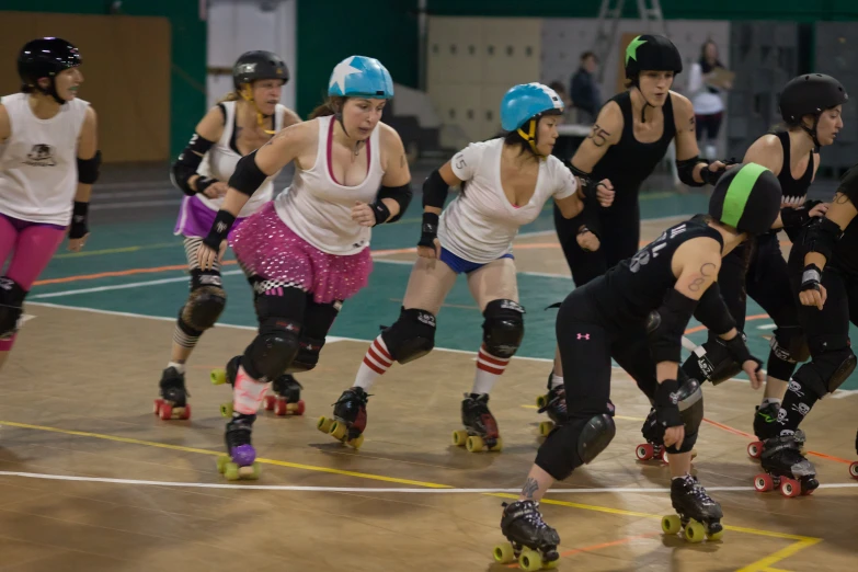 a group of women rollerblading on a rink