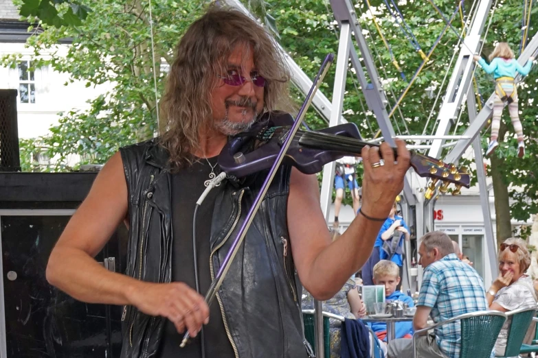 a man is standing under an umbrella playing guitar