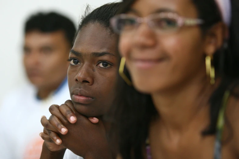 a girl with glasses and a guy standing behind her