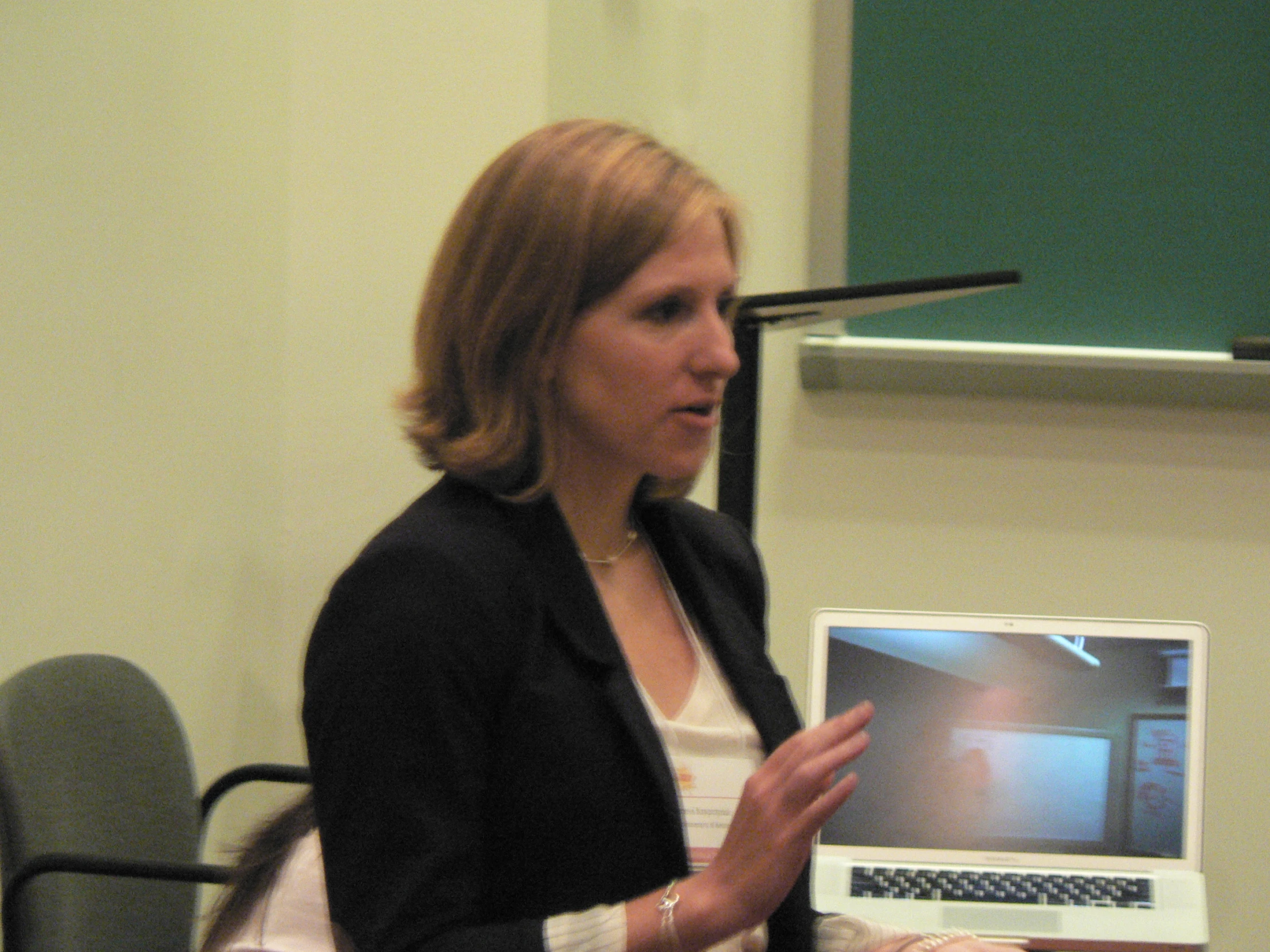 a woman standing in front of a laptop