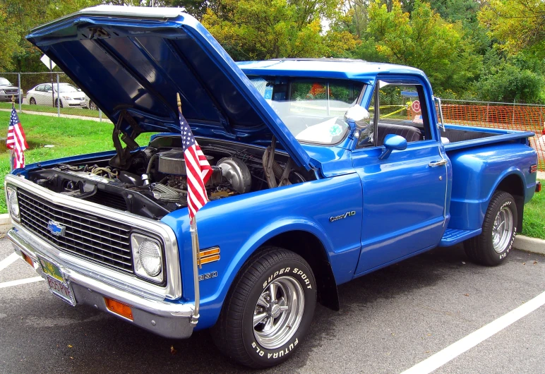 an american flag under a blue pickup truck