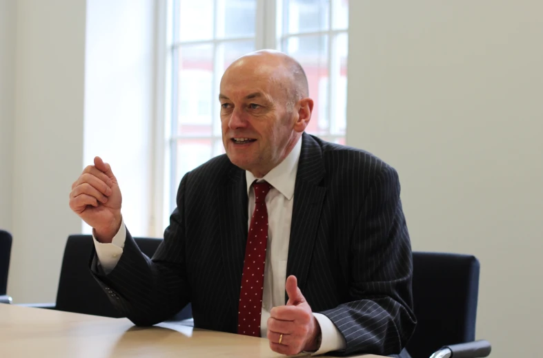 a man giving a thumbs up sitting at a table