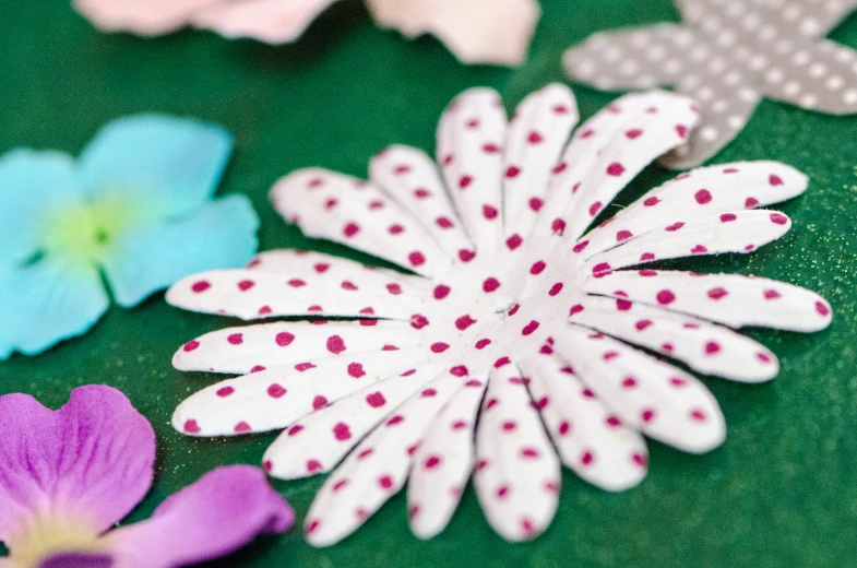 flowers, fabric and white pins sitting on a table