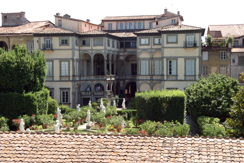 a very big house by some trees and bushes