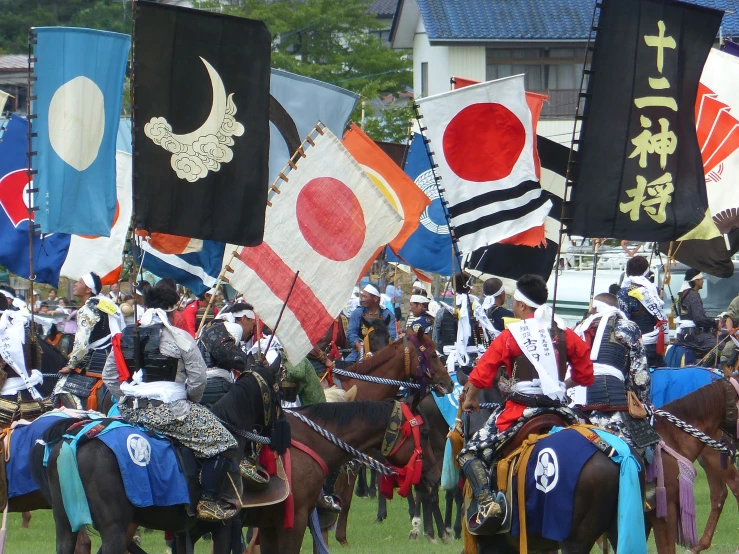 a large group of people on horses with various flags