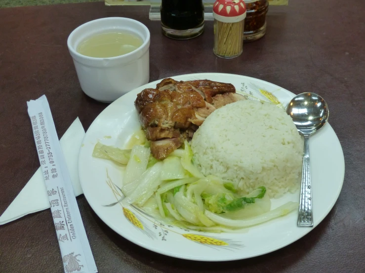 a plate topped with rice, meat and vegetables